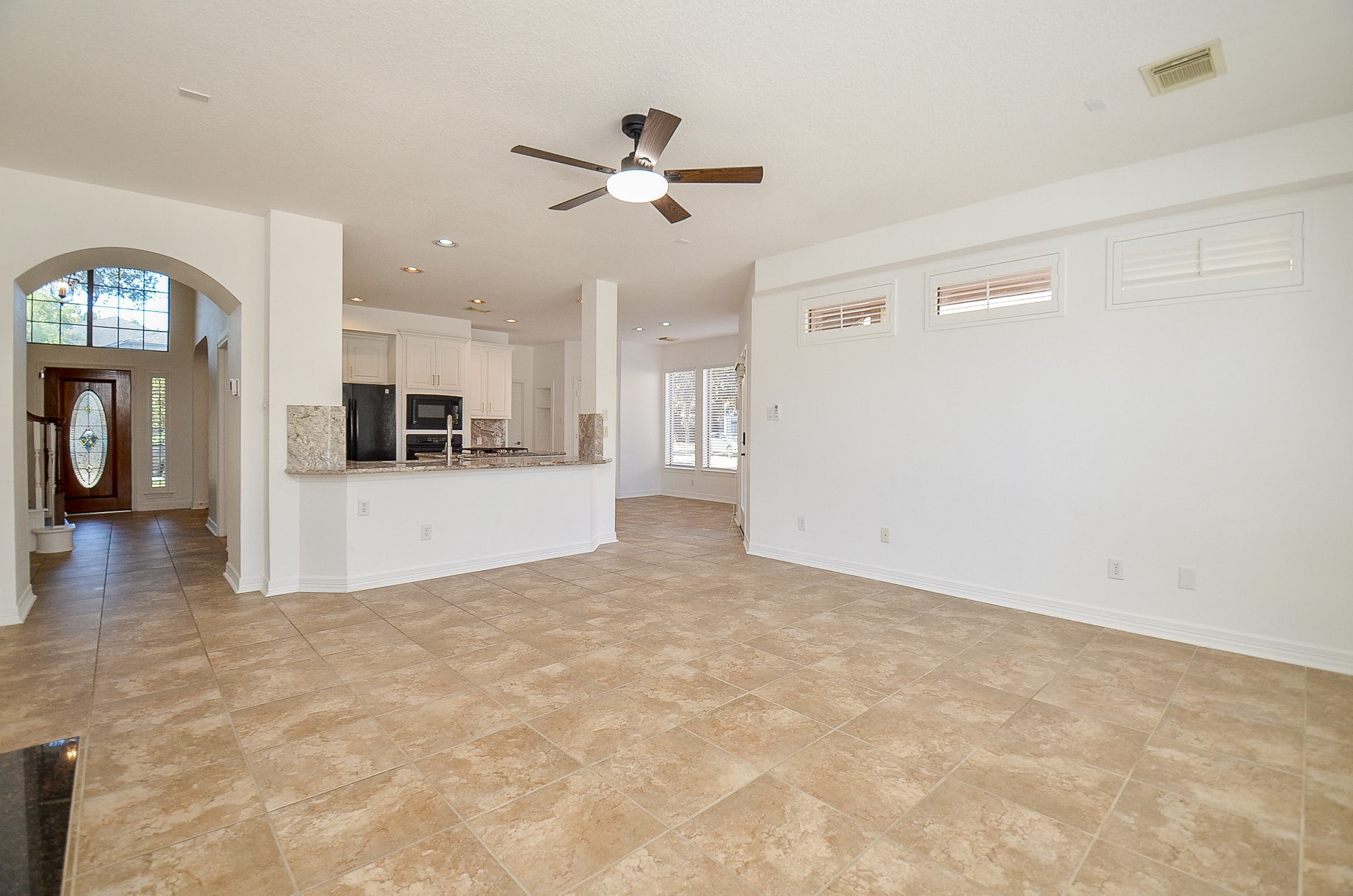 5615 Bent Arbor Lane Katy, TX 77450 - Photo 9 of 42 View of the den from the back of the house. Foyer is seen on the left. Kitchen is open to the den via an extended breakfast bar with room for several stools to provide additional dinner guests. Don't you just love the shuttered windows above the long wall for light with privacy?
