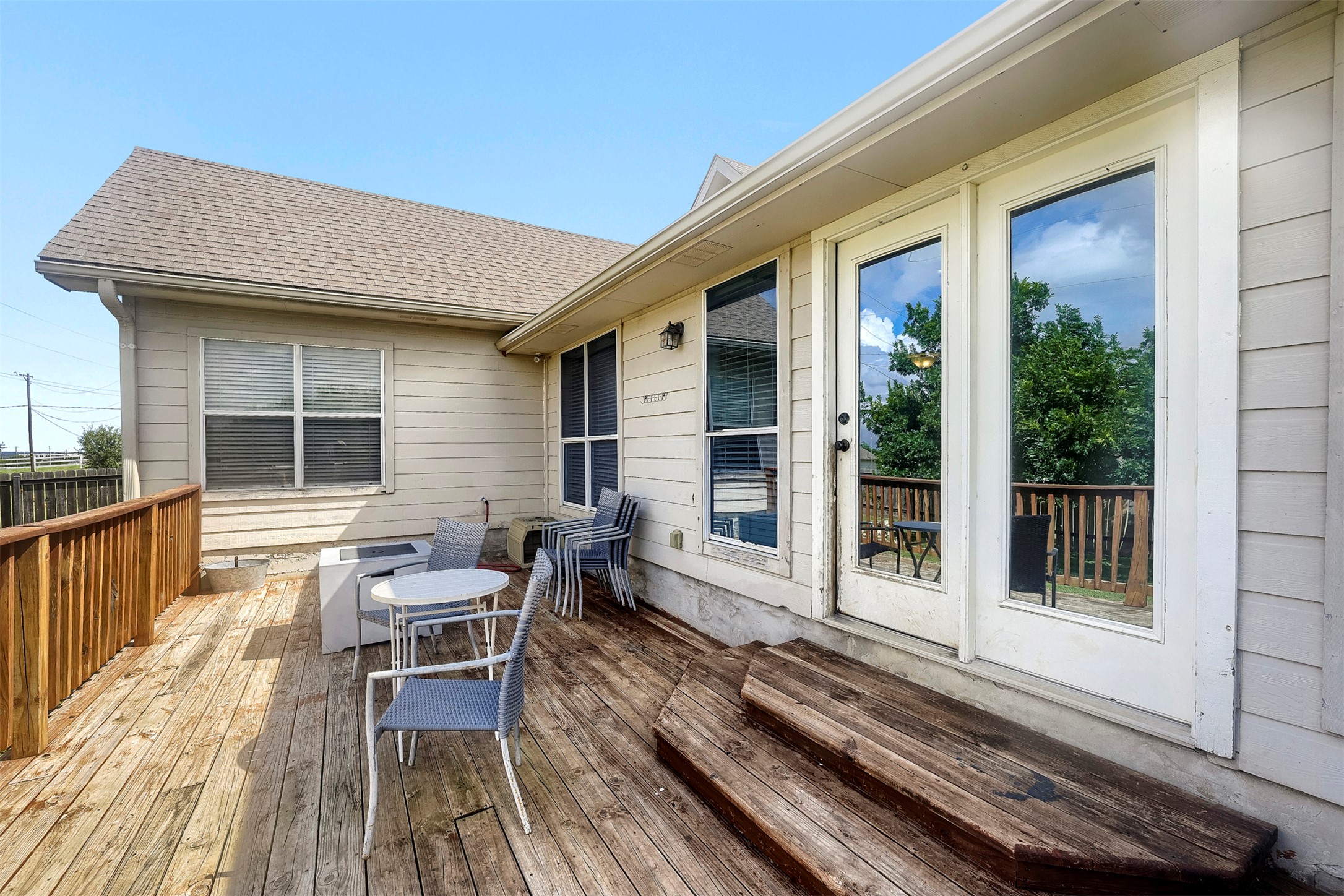 1105 2nd Street Jarrell, TX 76537 - Photo 23 of 27 A spacious outdoor wooden deck extends from the house, offering ample space for entertaining and relaxation.