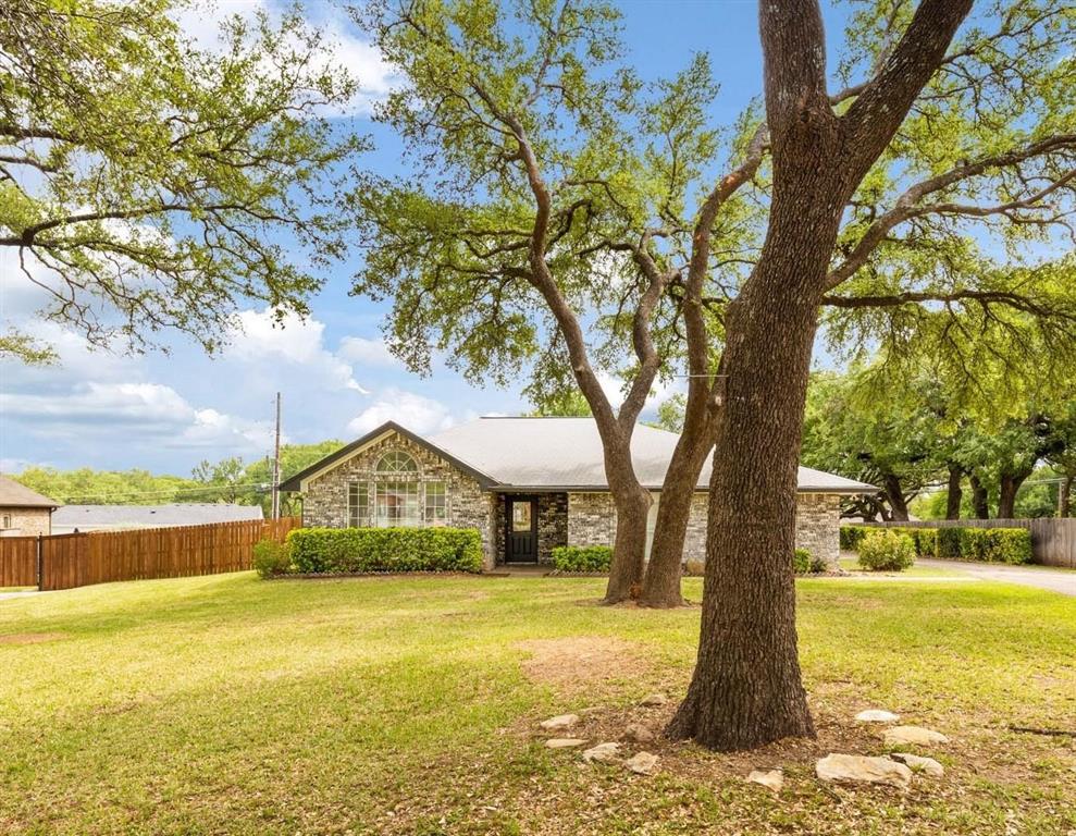 a front view of a house with a yard and trees