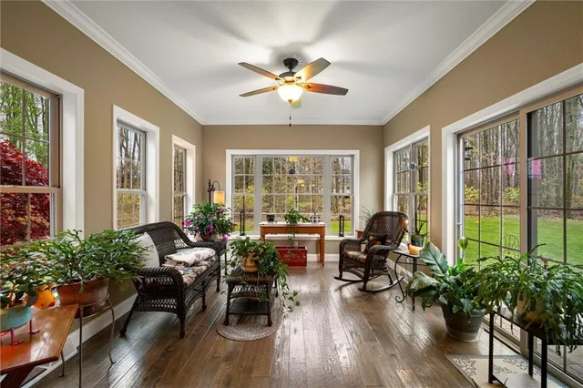a living room with furniture and a large window with wooden floor