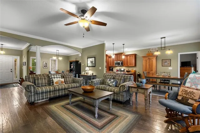 a living room with furniture kitchen view and a chandelier