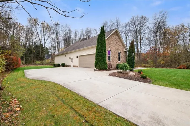 a view of a white house with a yard and potted plants