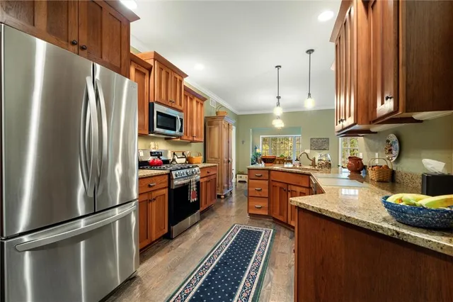 a kitchen with stainless steel appliances granite countertop a refrigerator a stove top oven a sink and dishwasher