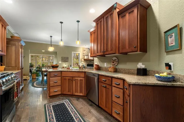 a kitchen with stainless steel appliances granite countertop a sink stove and refrigerator