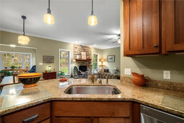 a kitchen with stainless steel appliances granite countertop a sink a counter space cabinets and furniture