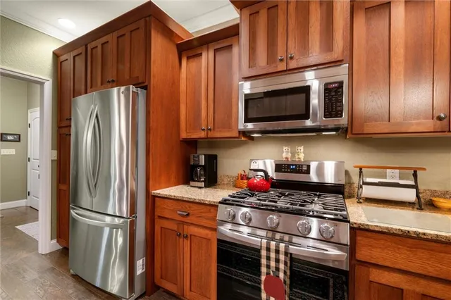 a kitchen with stainless steel appliances granite countertop a refrigerator stove and microwave