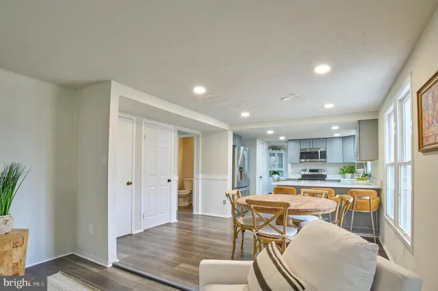 a kitchen with stainless steel appliances granite countertop a refrigerator a stove a sink dishwasher and white cabinets with wooden floor