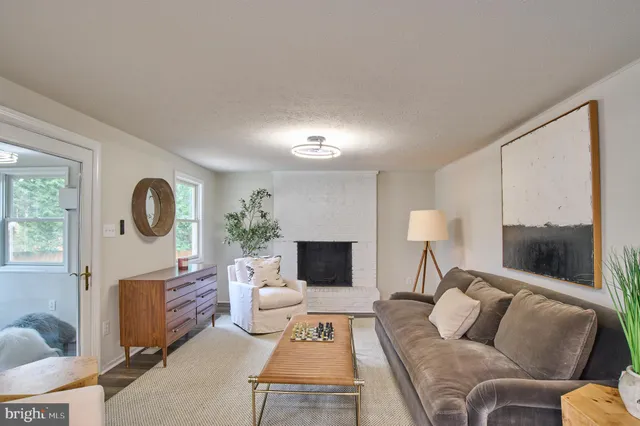 a living room with furniture fireplace and a window