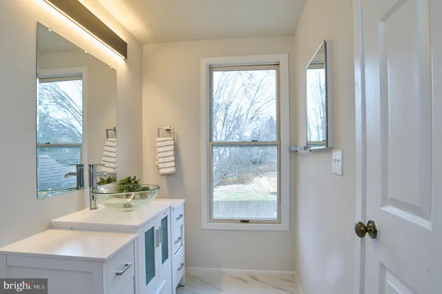 a bathroom with a double vanity sink and a window