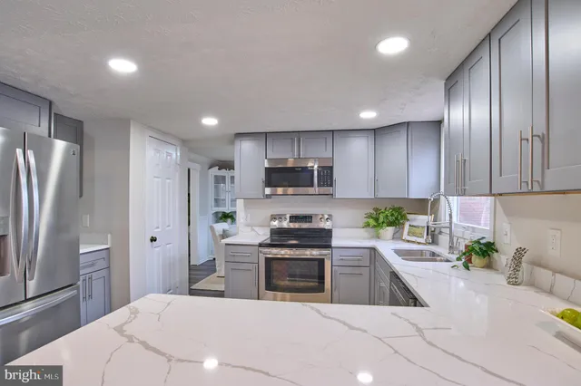 a kitchen with stainless steel appliances a refrigerator sink and stove