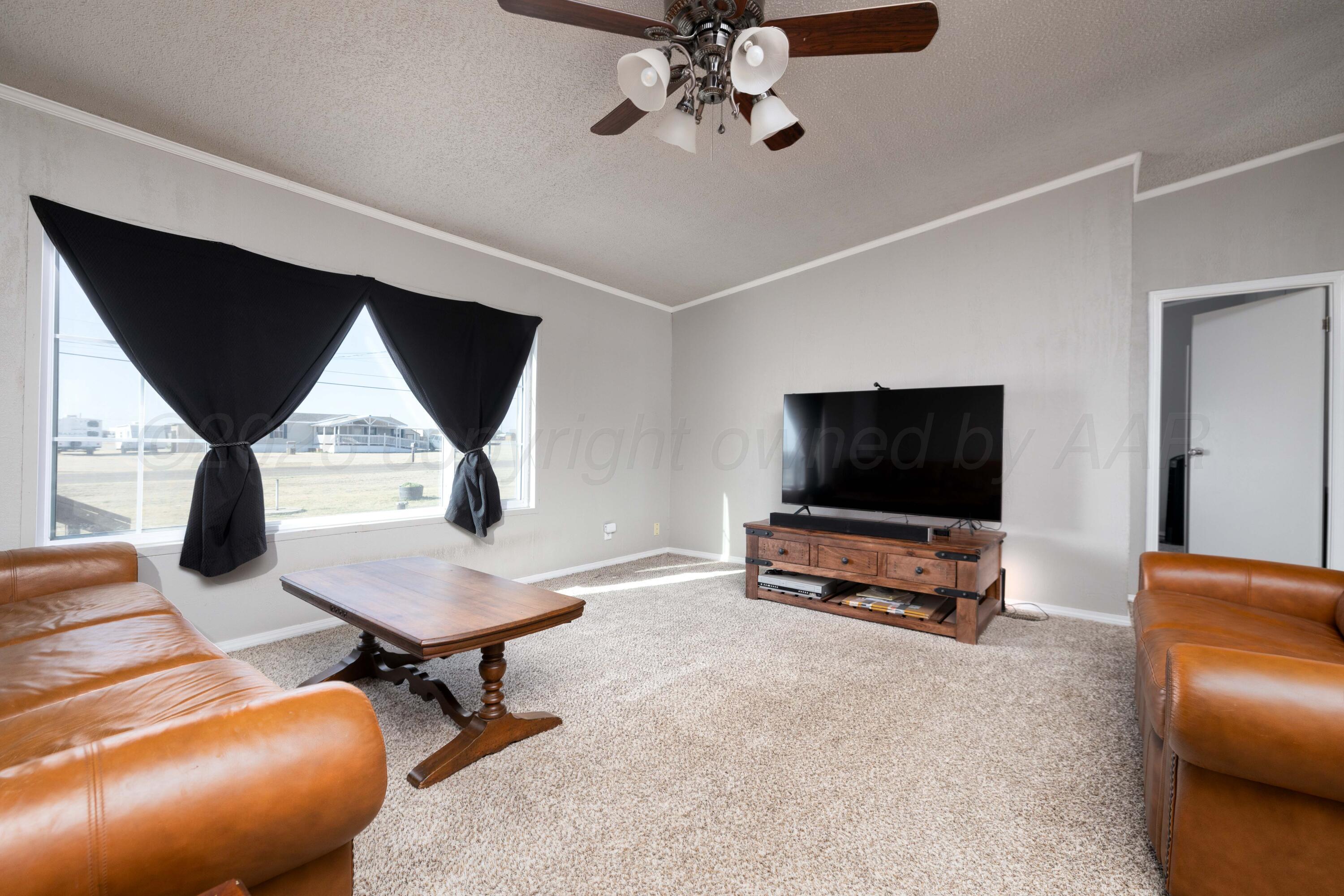 5410 Tranquility Road Amarillo, TX 79118 - Photo 12 of 37 a living room with furniture and a flat screen tv