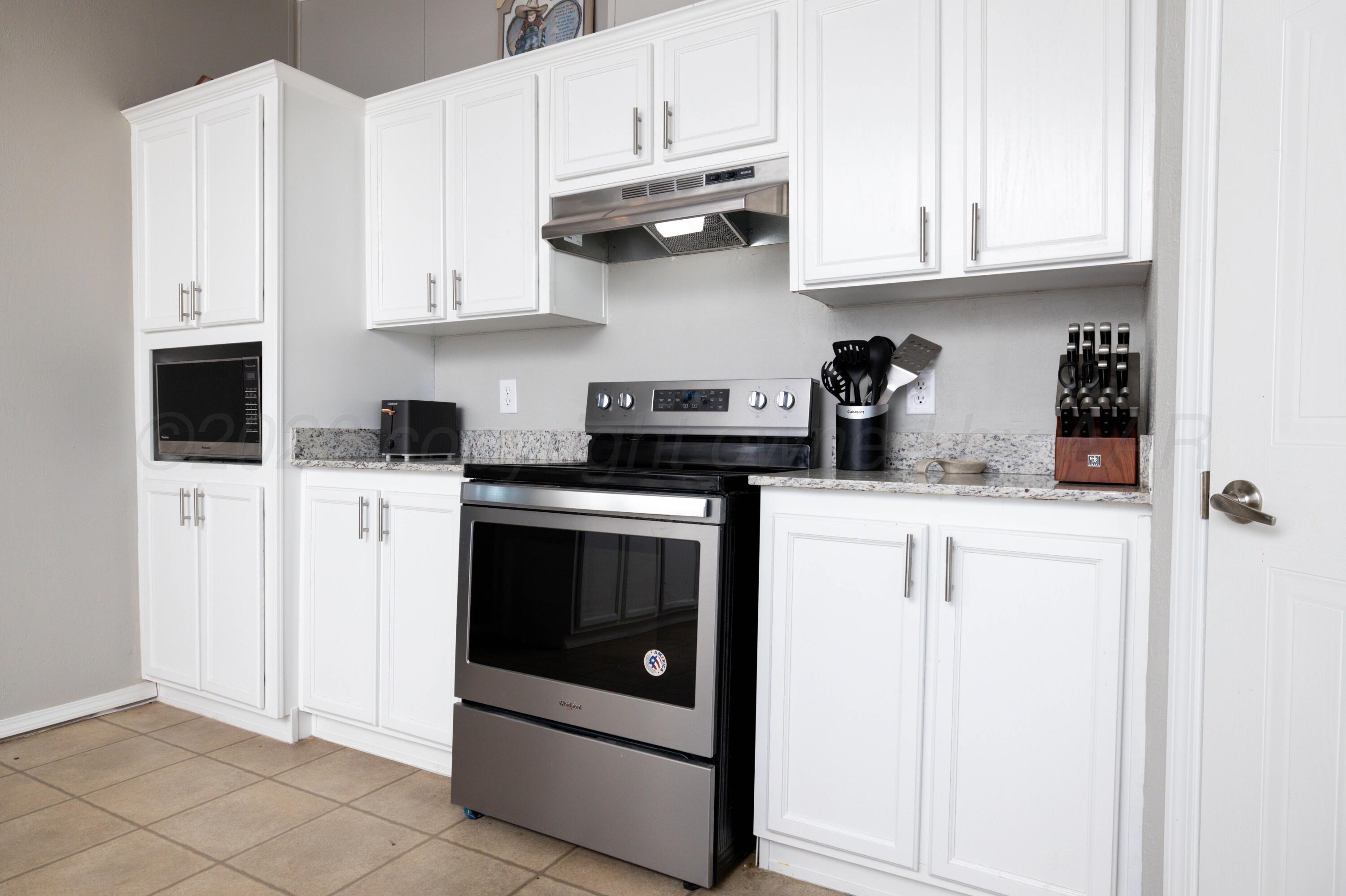 5410 Tranquility Road Amarillo, TX 79118 - Photo 15 of 37 a kitchen with stainless steel appliances granite countertop white cabinets and a stove
