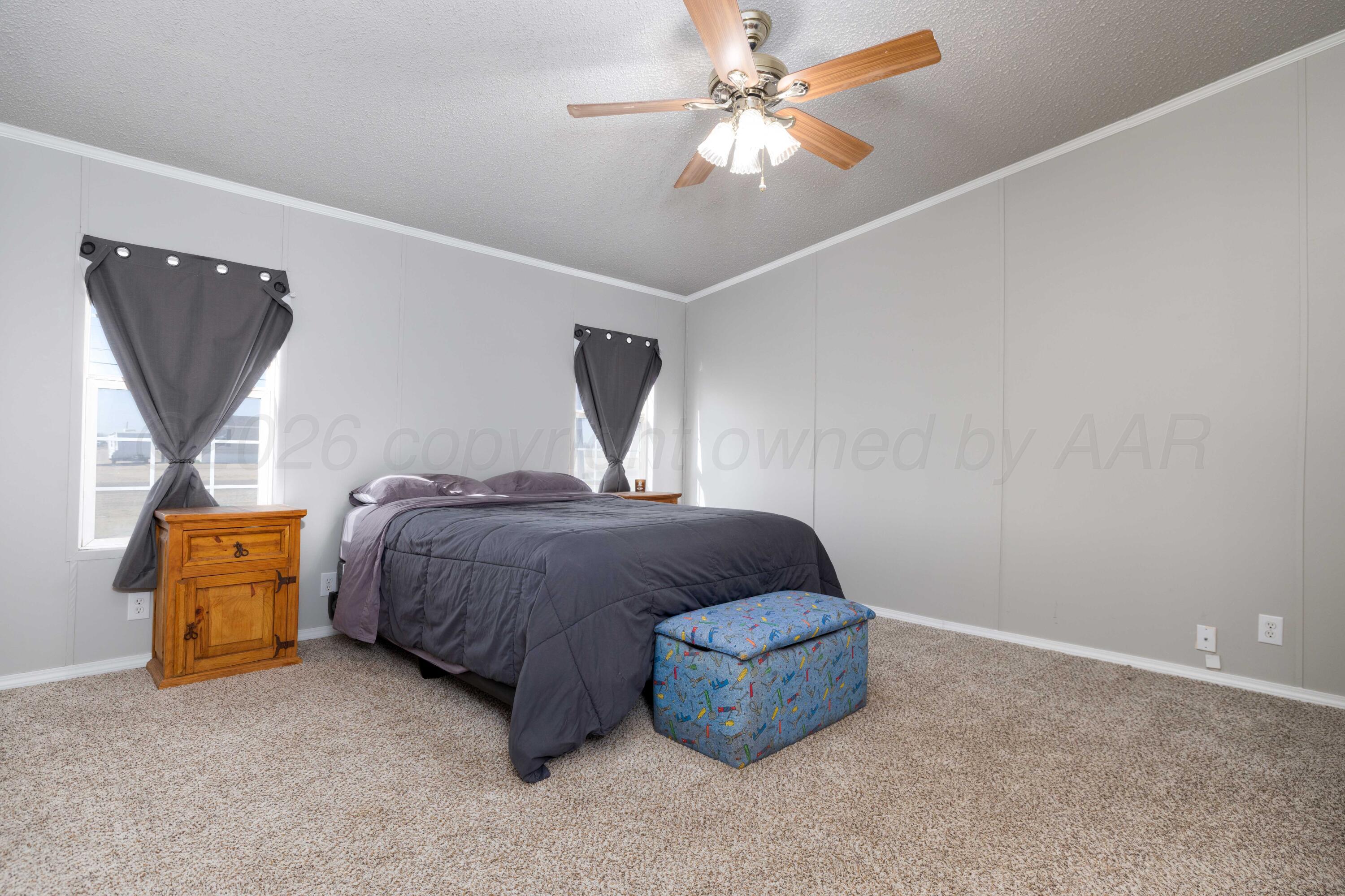 5410 Tranquility Road Amarillo, TX 79118 - Photo 18 of 37 a bedroom with a bed and a chandelier