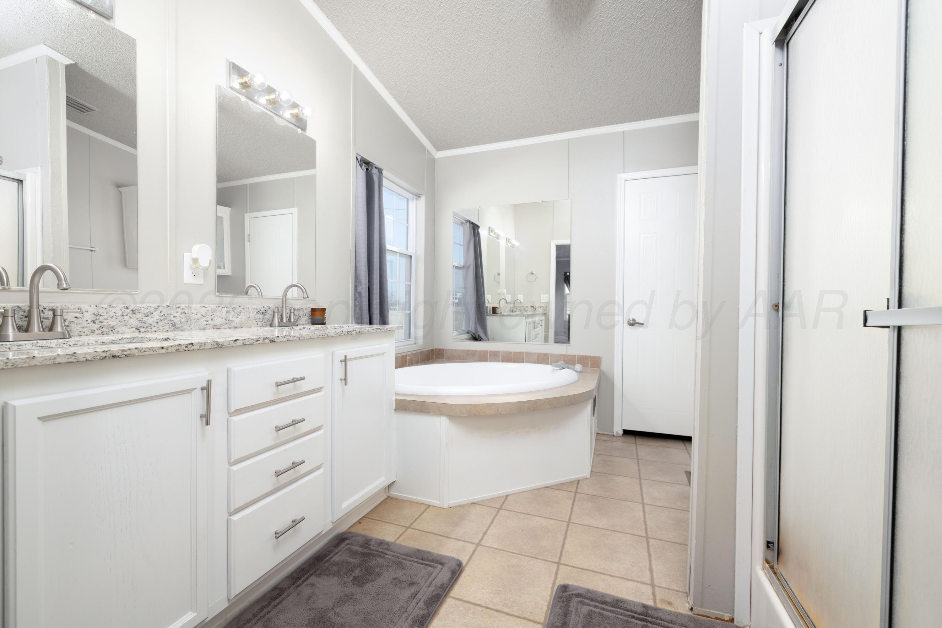 5410 Tranquility Road Amarillo, TX 79118 - Photo 21 of 37 a bathroom with a granite countertop sink mirror and bathtub
