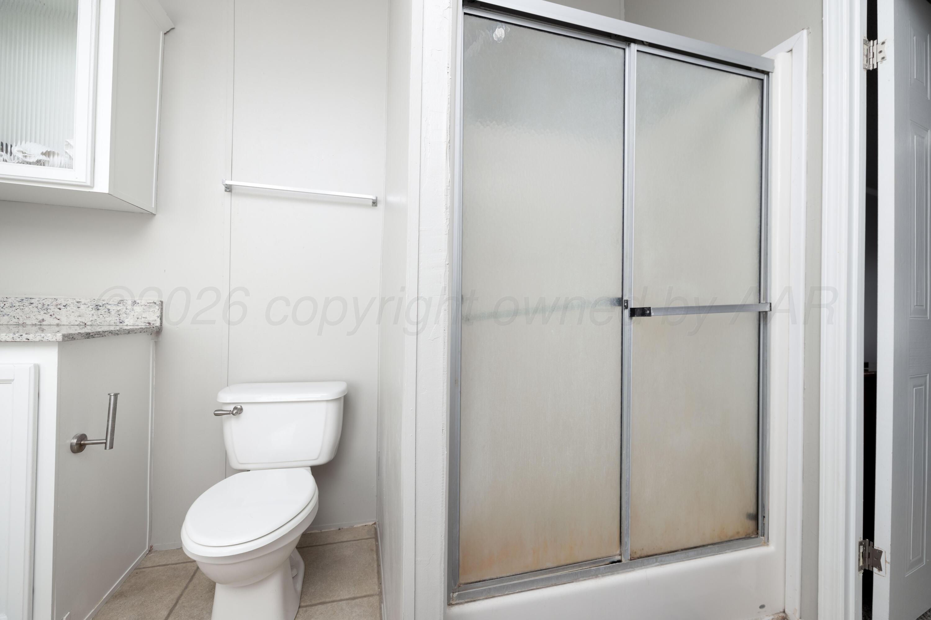 5410 Tranquility Road Amarillo, TX 79118 - Photo 23 of 37 a bathroom with a toilet and a shower