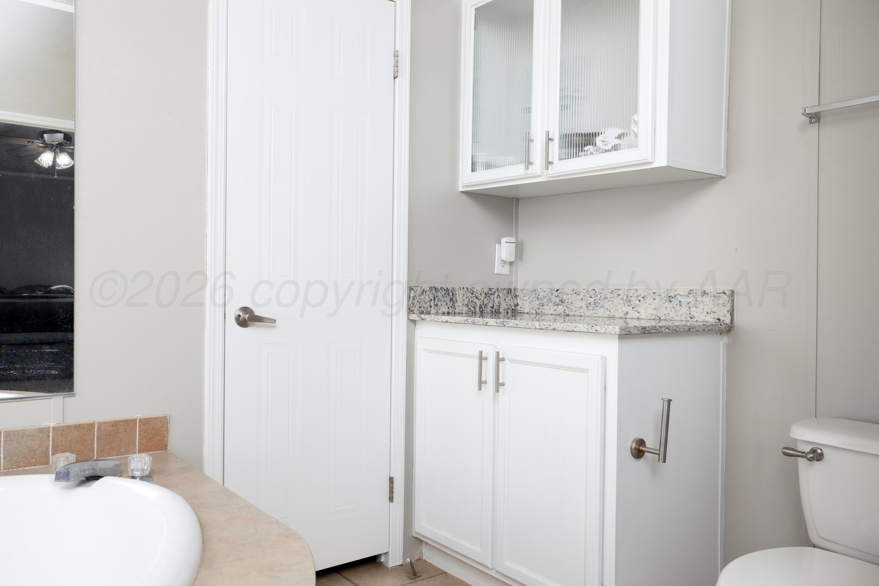 5410 Tranquility Road Amarillo, TX 79118 - Photo 24 of 37 a bathroom with a granite countertop sink and a toilet