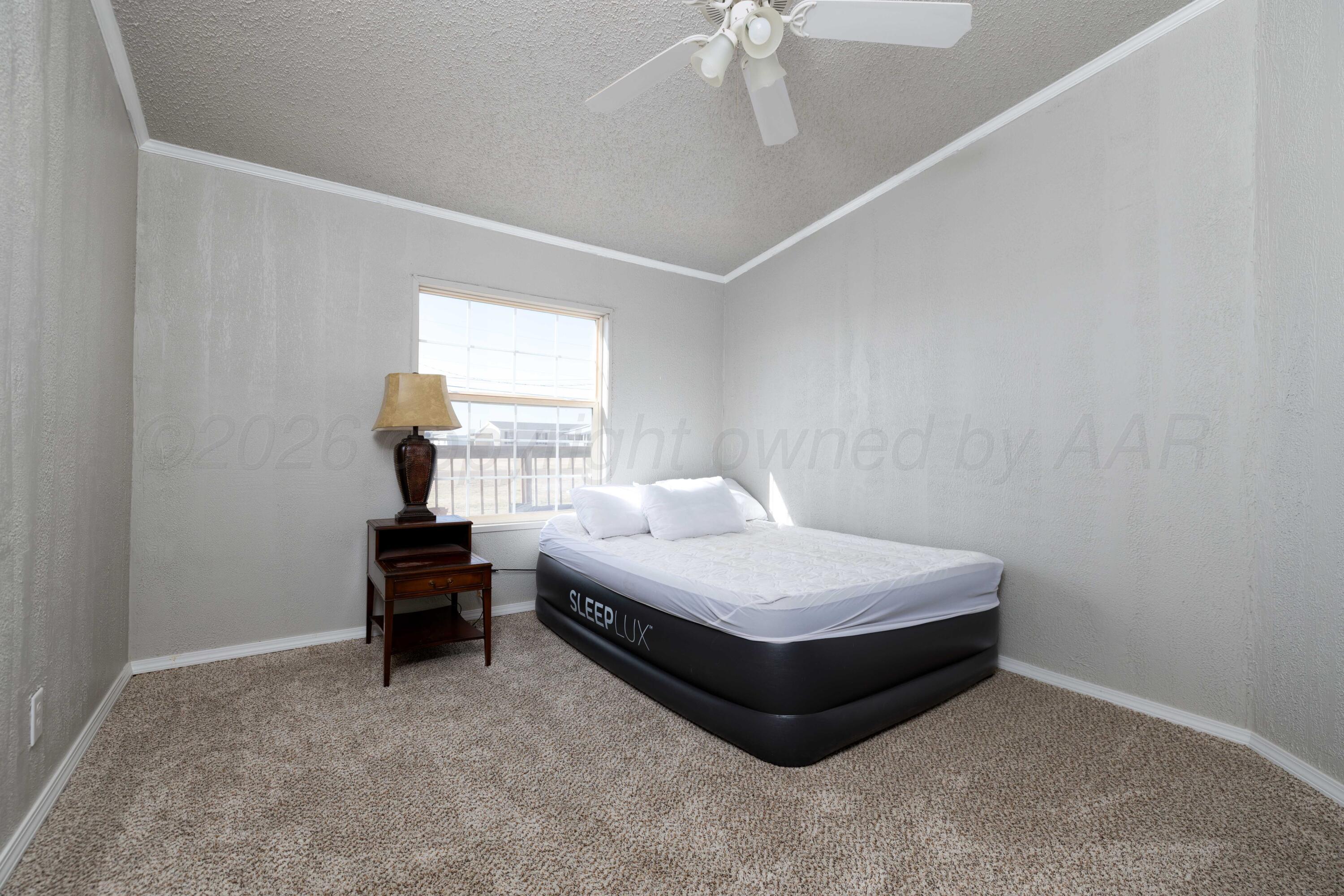 5410 Tranquility Road Amarillo, TX 79118 - Photo 26 of 37 a bedroom with a bed and a chandelier