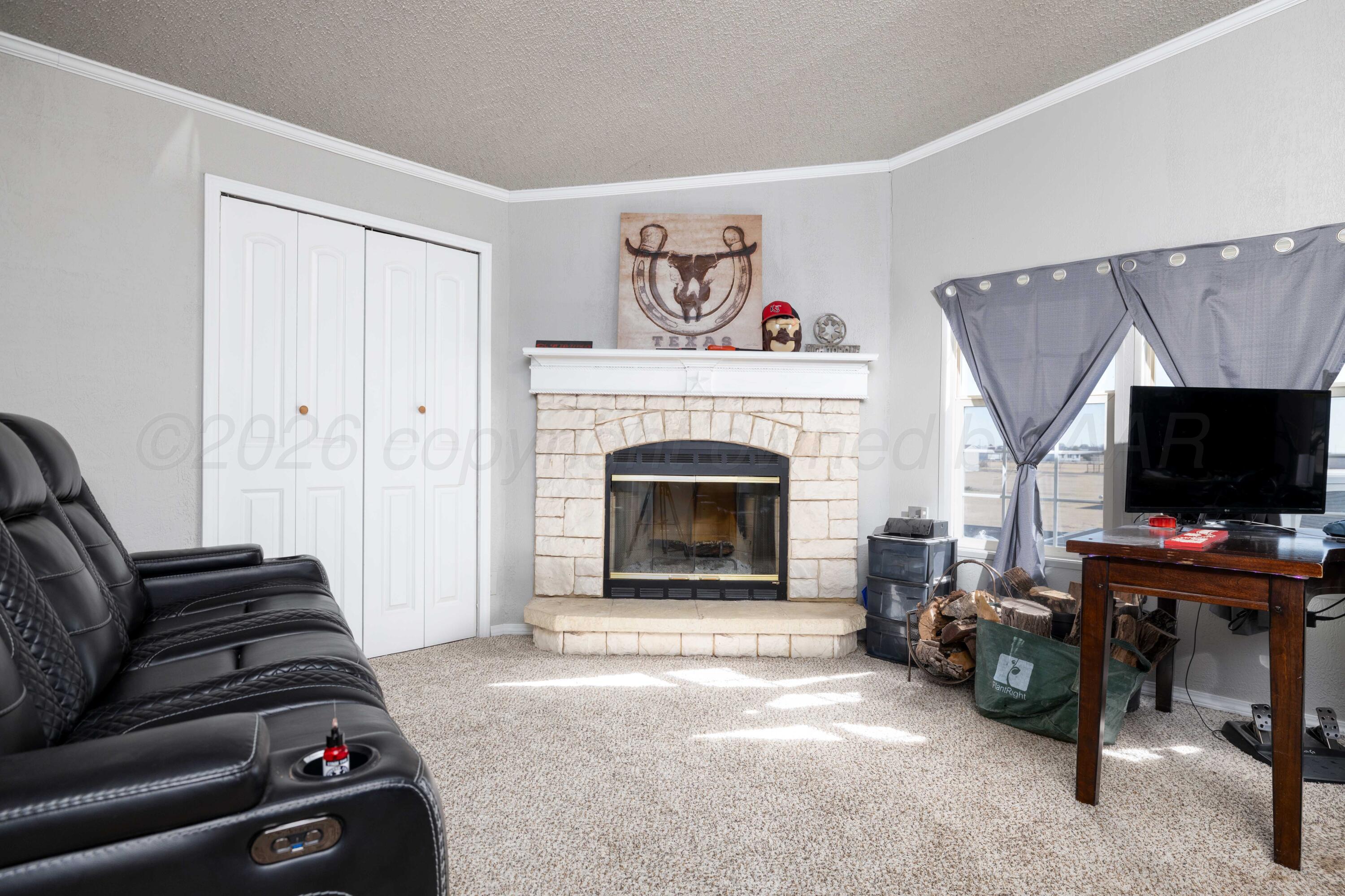 5410 Tranquility Road Amarillo, TX 79118 - Photo 33 of 37 a living room with furniture a flat screen tv and a fireplace