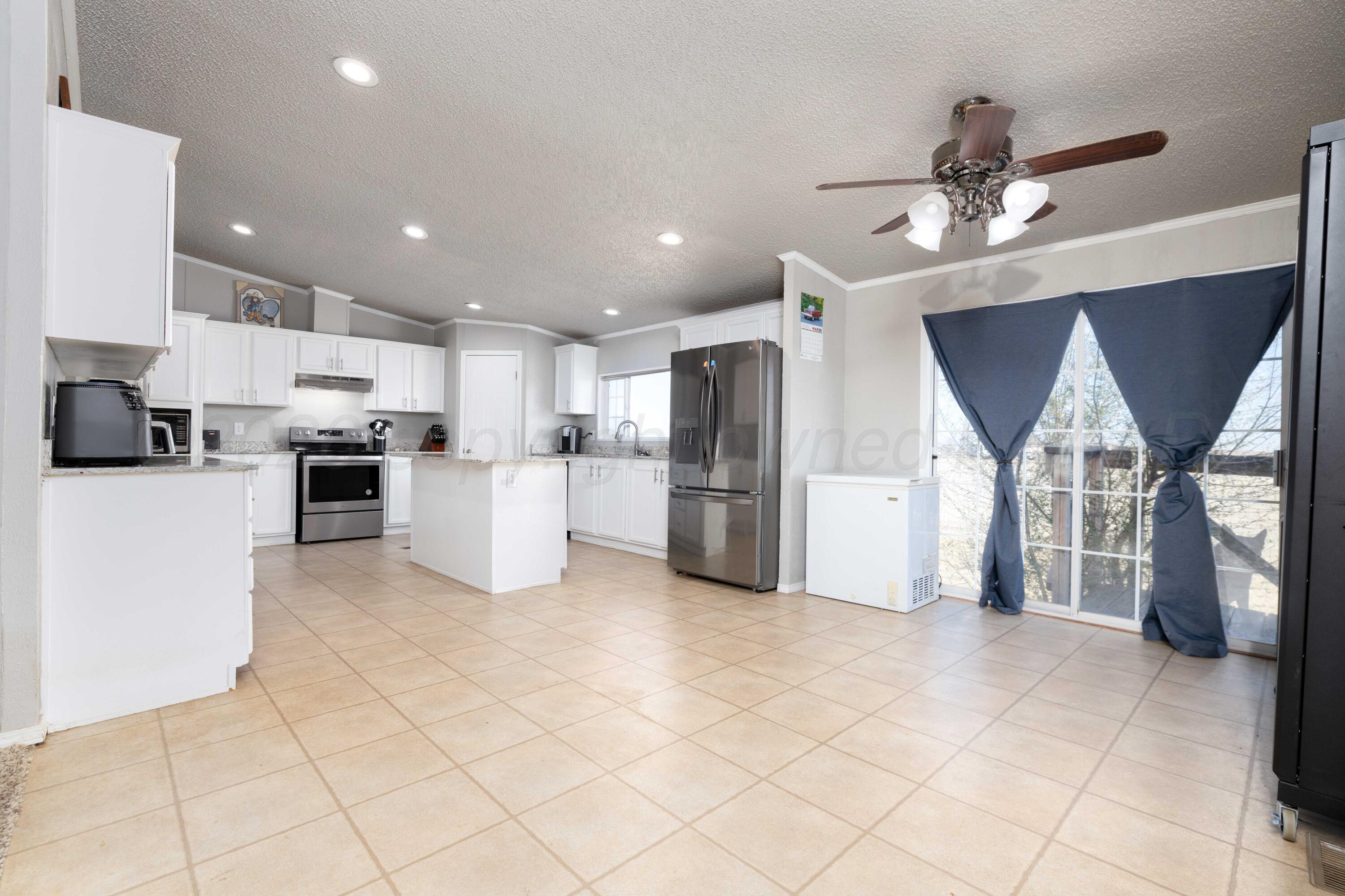 5410 Tranquility Road Amarillo, TX 79118 - Photo 8 of 37 a kitchen with stainless steel appliances kitchen island granite countertop a refrigerator and a stove top oven