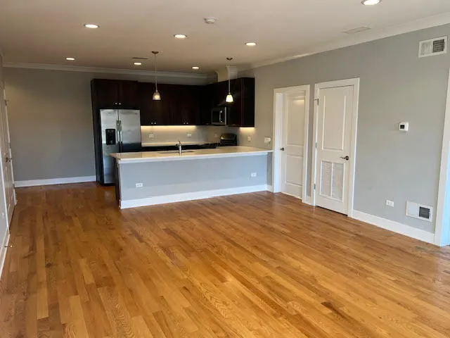 a view of kitchen with kitchen island granite countertop a sink and refrigerator