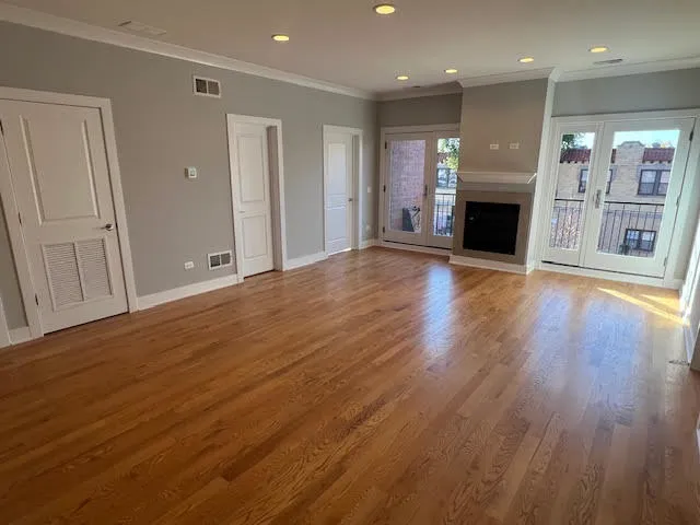 an empty room with wooden floor and a fireplace