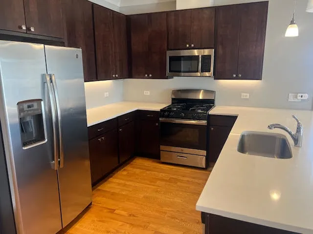 a kitchen with stainless steel appliances a refrigerator a stove a microwave and cabinets