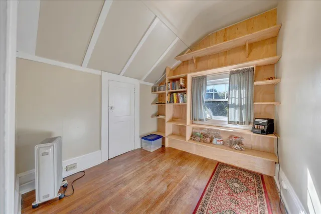 a spacious bedroom with a bed and wooden floor