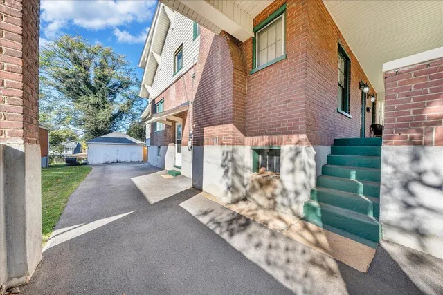 a view of a house with a yard and a large tree