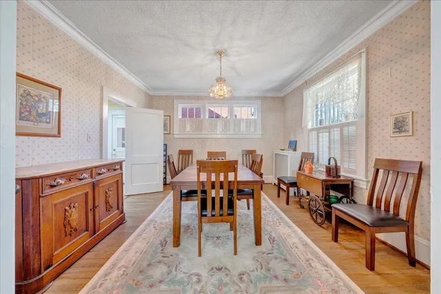 a very nice looking living room with a large window and a dining table