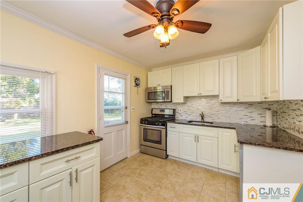 68 Sturgis Road Edison, NJ 08817 - Photo 7 of 25 a kitchen with granite countertop stainless steel appliances a stove a sink and a microwave
