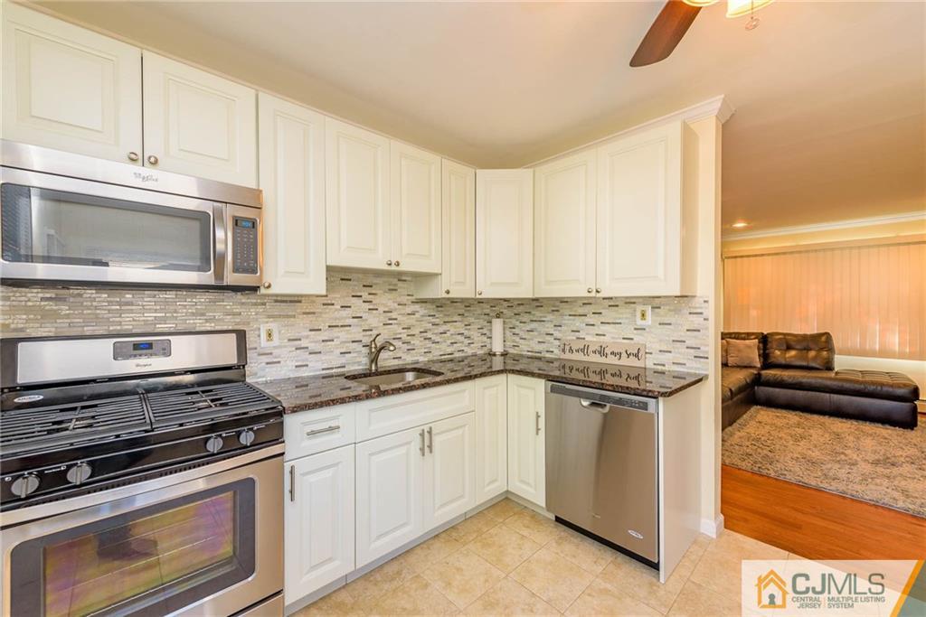 68 Sturgis Road Edison, NJ 08817 - Photo 8 of 25 a kitchen with granite countertop a stove sink and cabinets