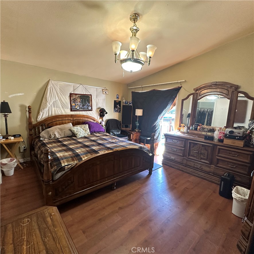 1335 Mountview Road Lakeport, CA 95453 - Photo 18 of 54 a bedroom with a large bed a chandelier and dresser