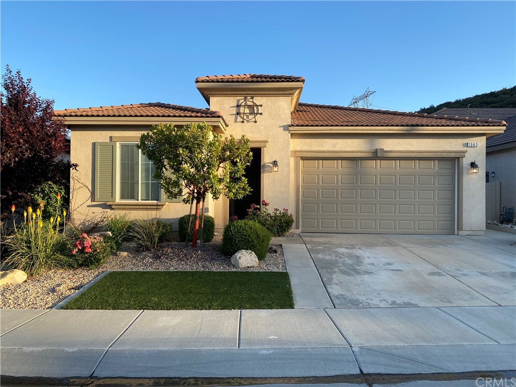 1563 Savannah Creek Beaumont, CA 92223 - Photo 1 of 28 a front view of a house with a yard and garage