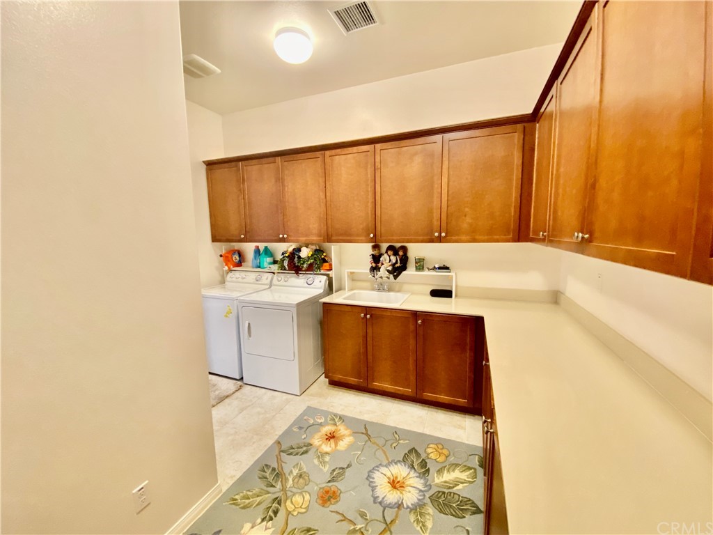 1563 Savannah Creek Beaumont, CA 92223 - Photo 12 of 28 a utility room with a sink a washer and dryer