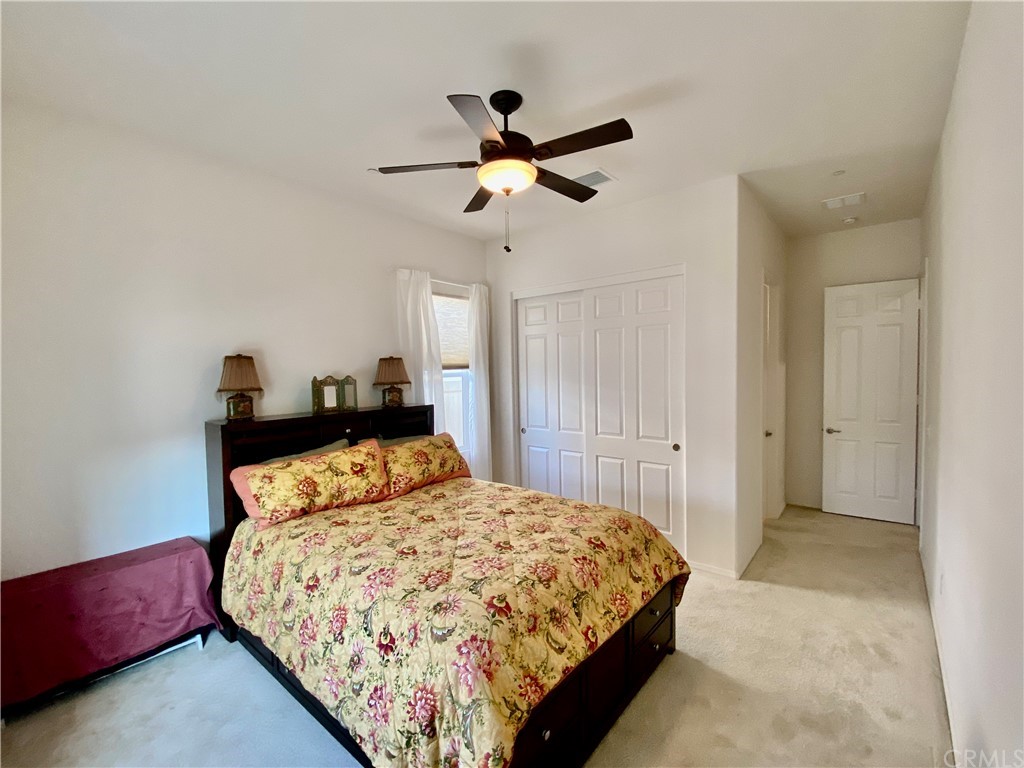 1563 Savannah Creek Beaumont, CA 92223 - Photo 14 of 28 a bedroom with a bed and a chandelier