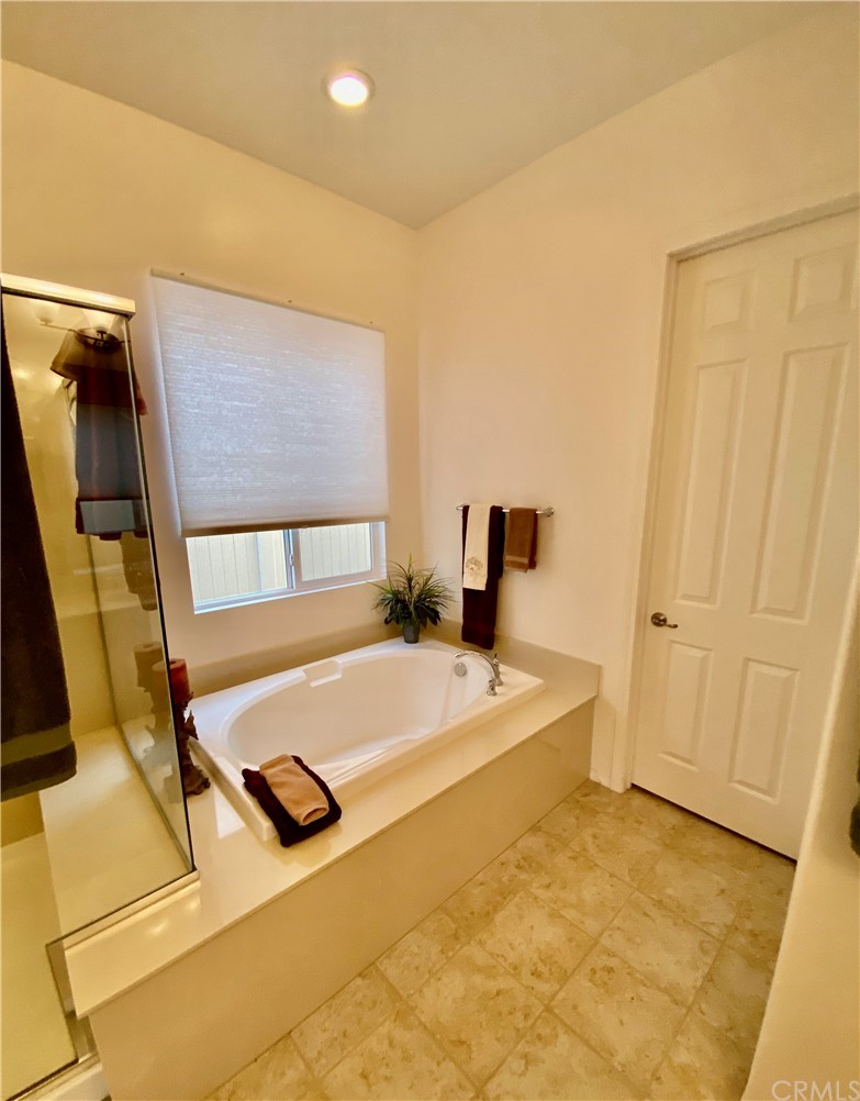 1563 Savannah Creek Beaumont, CA 92223 - Photo 22 of 28 a spacious bedroom with a bed and a flat screen tv