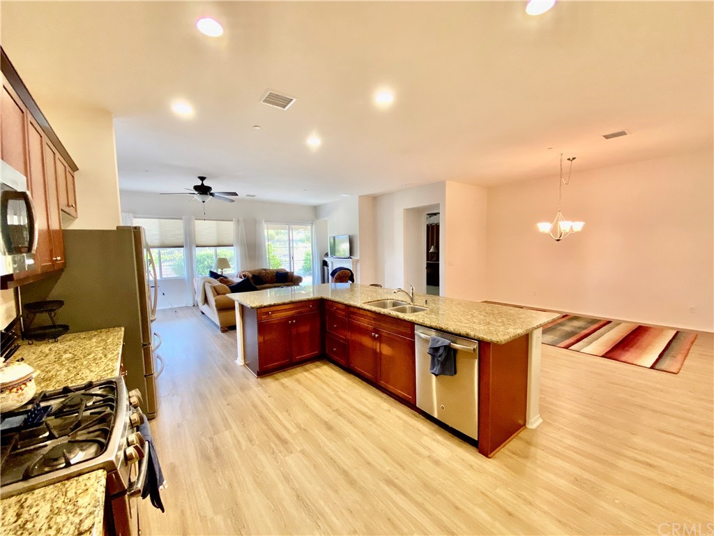 1563 Savannah Creek Beaumont, CA 92223 - Photo 5 of 28 a large kitchen with stainless steel appliances granite countertop a large counter top a stove and a wooden floors