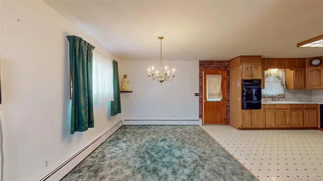 a view of a hallway with entryway and chandelier