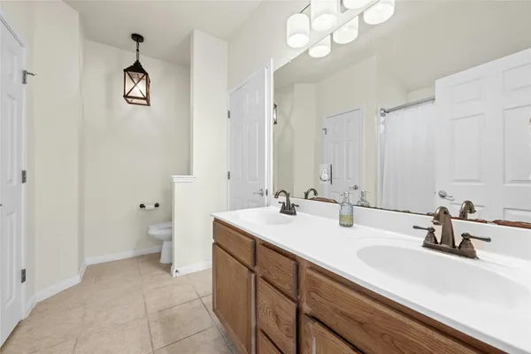 a bathroom with a sink a toilet and a mirror