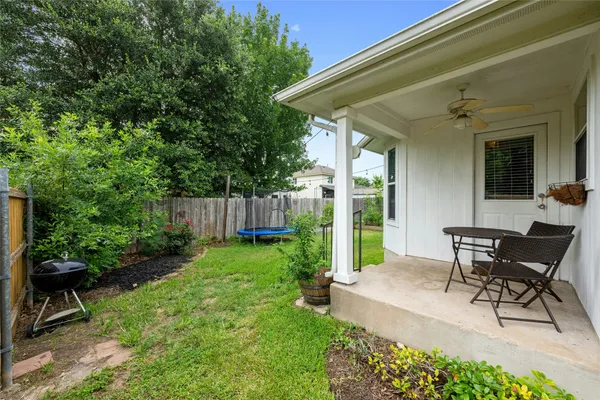 a view of a patio with table and chairs and potted plants with wooden fence