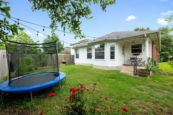 a view of a chair and table in backyard of the house