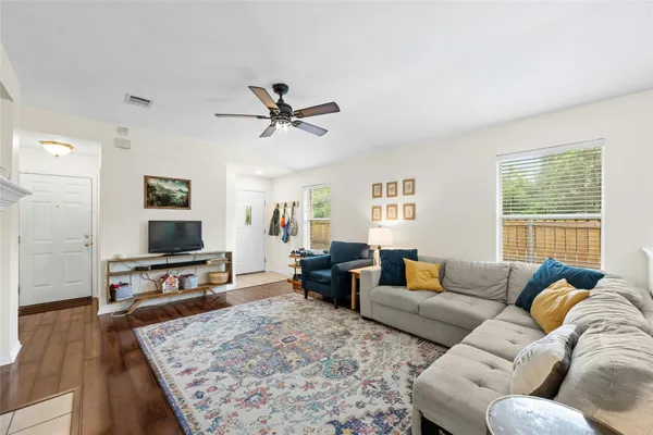 a living room with furniture flat screen tv and a wooden floor