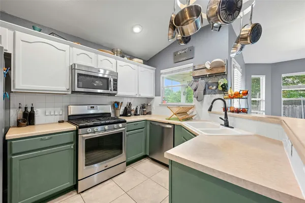 a kitchen with a sink a stove and cabinets