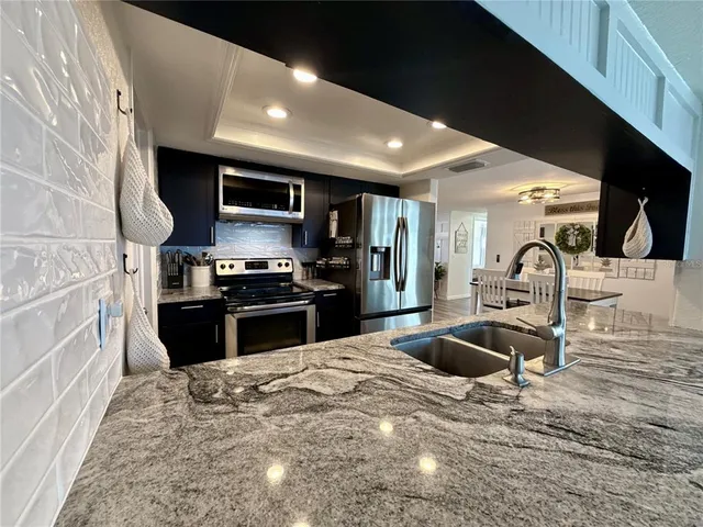a kitchen with granite countertop a stove and a refrigerator