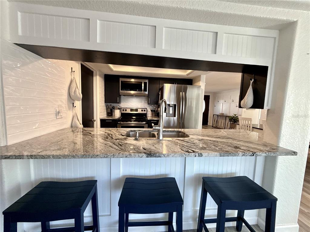 5129 Idlewild Street New Port Richey, FL 34653 - Photo 14 of 28 a kitchen with stainless steel appliances granite countertop a sink and a refrigerator