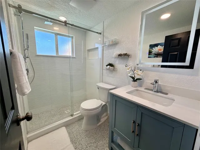 a bathroom with a sink a toilet and shower