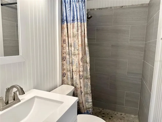a bathroom with a sink a toilet and shower