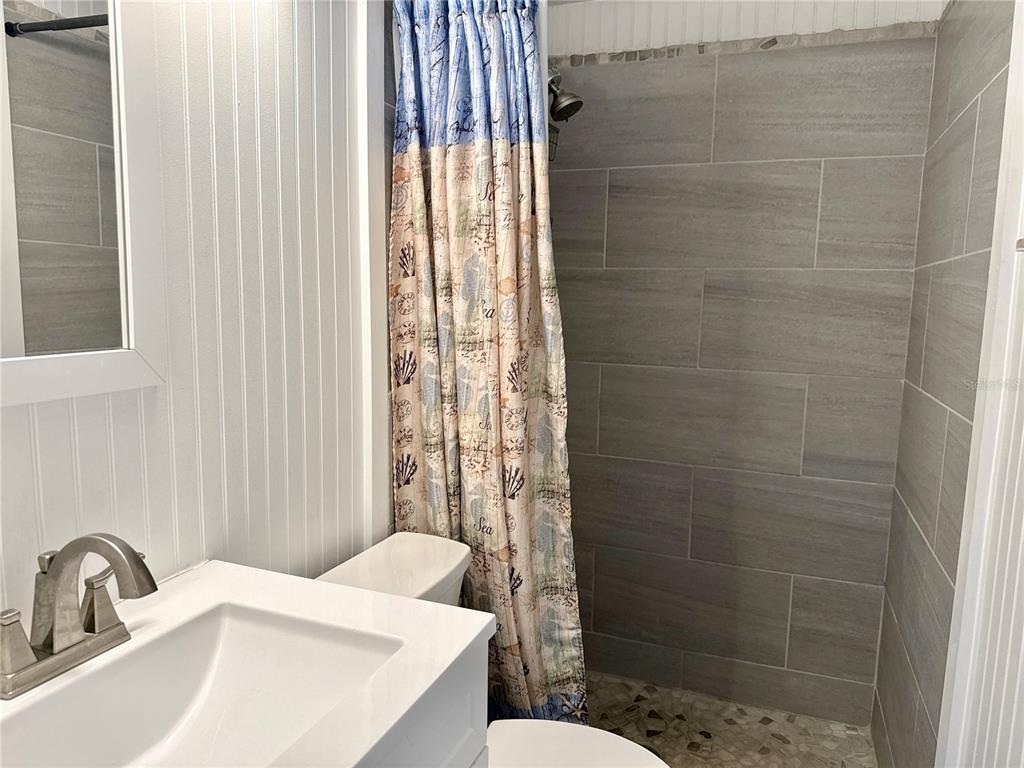 5129 Idlewild Street New Port Richey, FL 34653 - Photo 23 of 28 a bathroom with a sink a toilet and shower