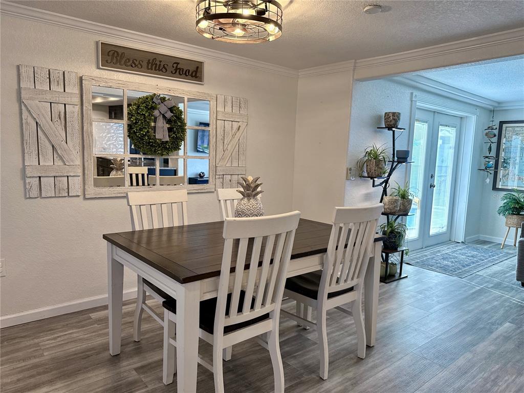 5129 Idlewild Street New Port Richey, FL 34653 - Photo 9 of 28 a dining room with furniture and wooden floor