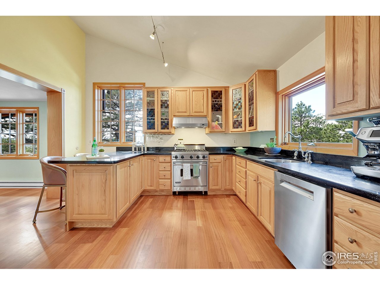 1319 County Road 83 Boulder, CO 80302 - Photo 5 of 30 a kitchen with stainless steel appliances granite countertop wooden cabinets a sink a stove a dining table and chairs